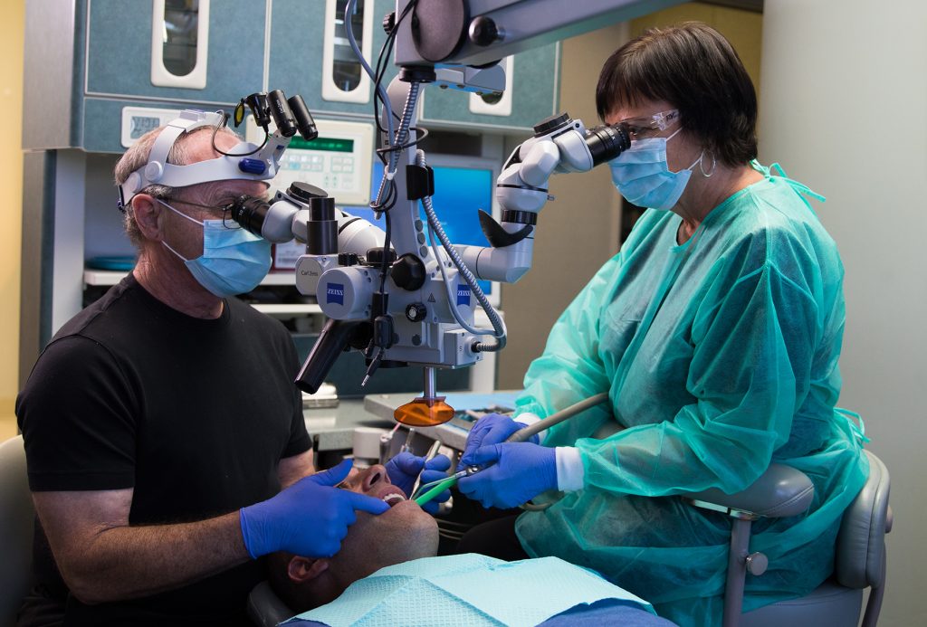 Doctor using equipment with patient during procedure