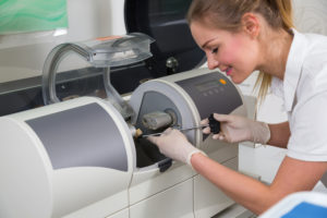 Dental assistant using cerec milling machine for dental implants in San Diego, CA
